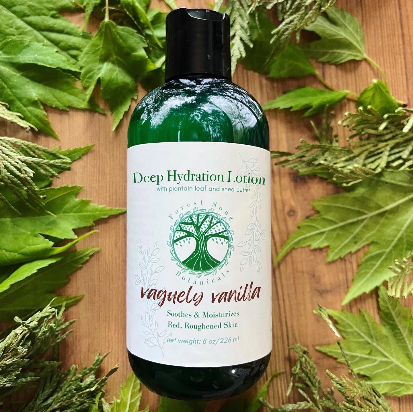 Green bottle with a white label that has a green tree logo and the words vaguely vanilla in italic script.